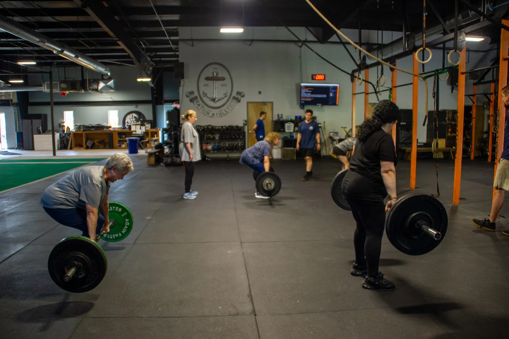 A full PLUS class trains barbell deadlifts together at Top Form Physical Therapy in Branford, Connecticut