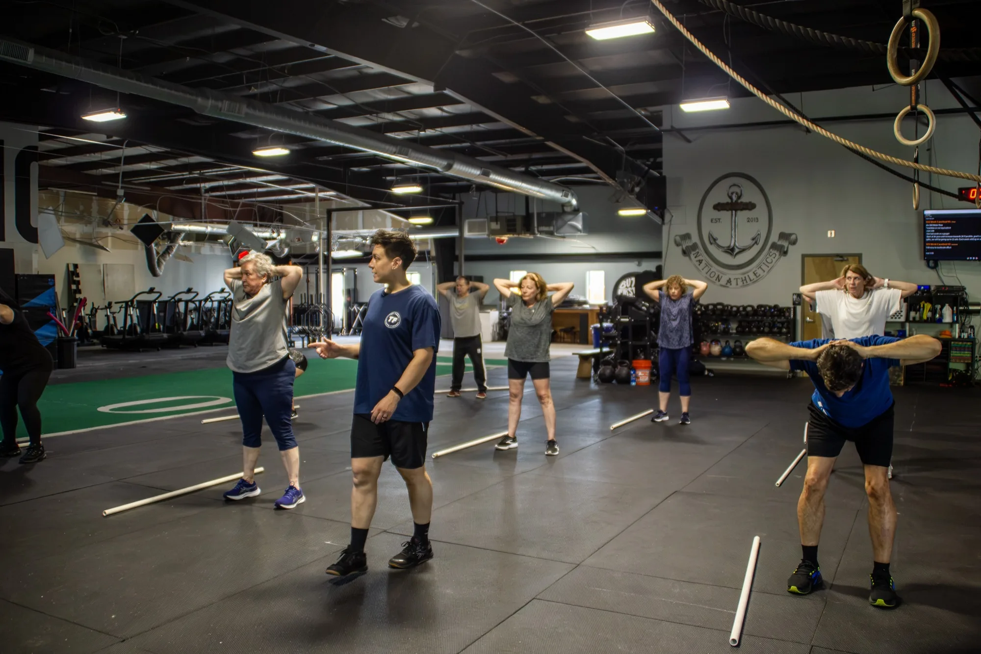 Older adults work through a guided mobility warmup during a PLUS class at Top Form Physical Therapy, Branford CT