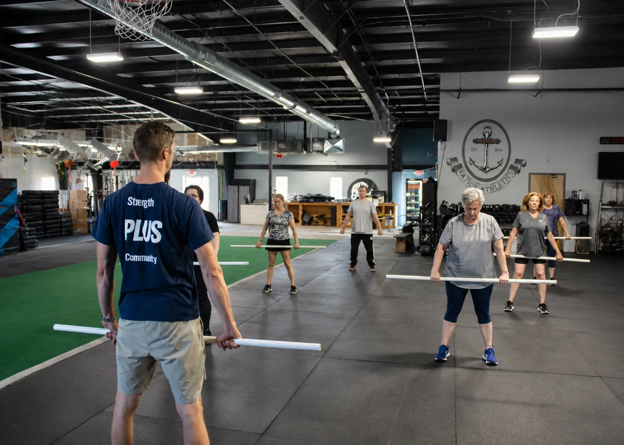 Coach Rich Krueger leads the full PLUS class through a synchronized warmup at Top Form Physical Therapy in Branford, Connecticut